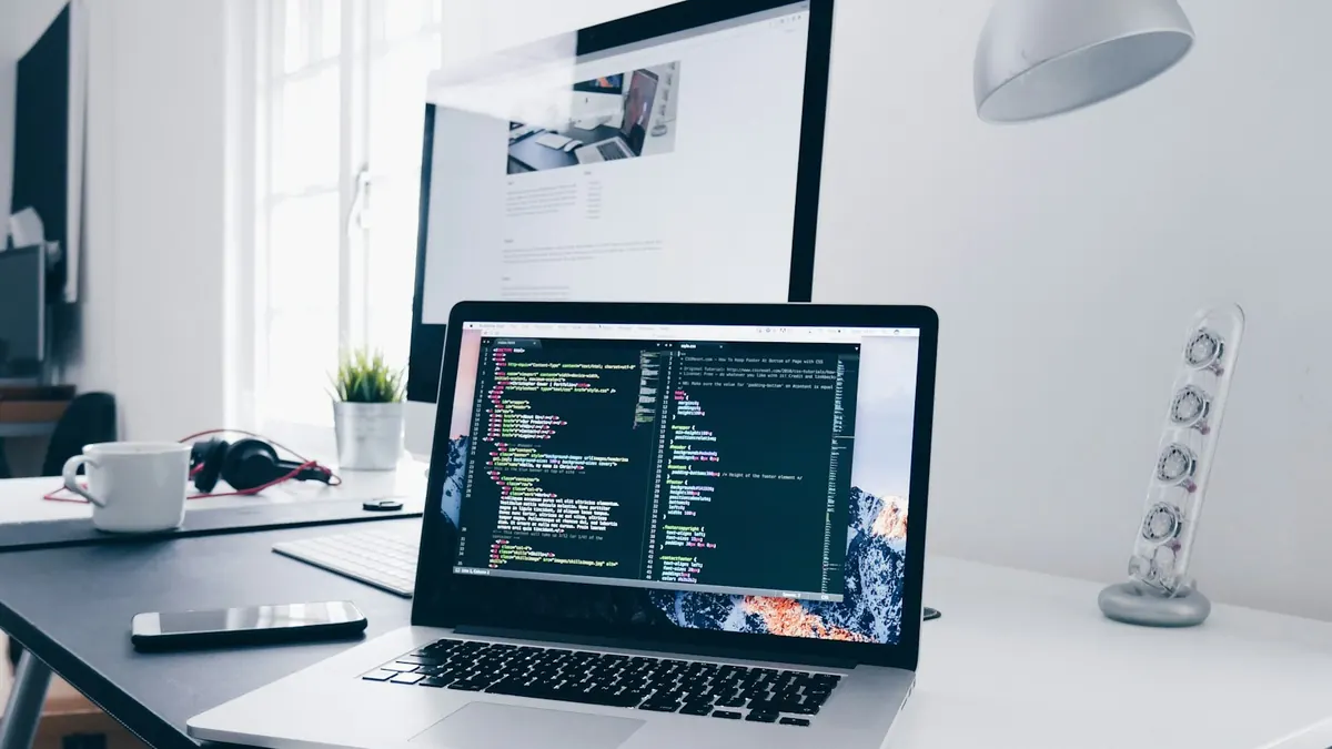IT-Arbeitsplatz mit Laptop und Code IT-Arbeitsplatz mit Laptop und Code