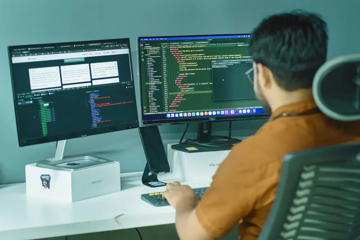 IT-Verantwortlicher überwacht IoT-Sensordaten und Netzwerk-Anomalien auf zwei Monitoren