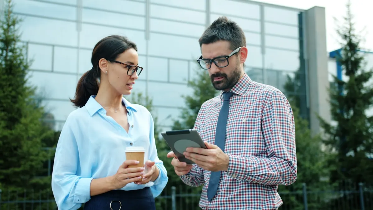 BYOD-Richtlinie: Zwei Kollegen diskutieren mobile Gerätestrategie am Tablet