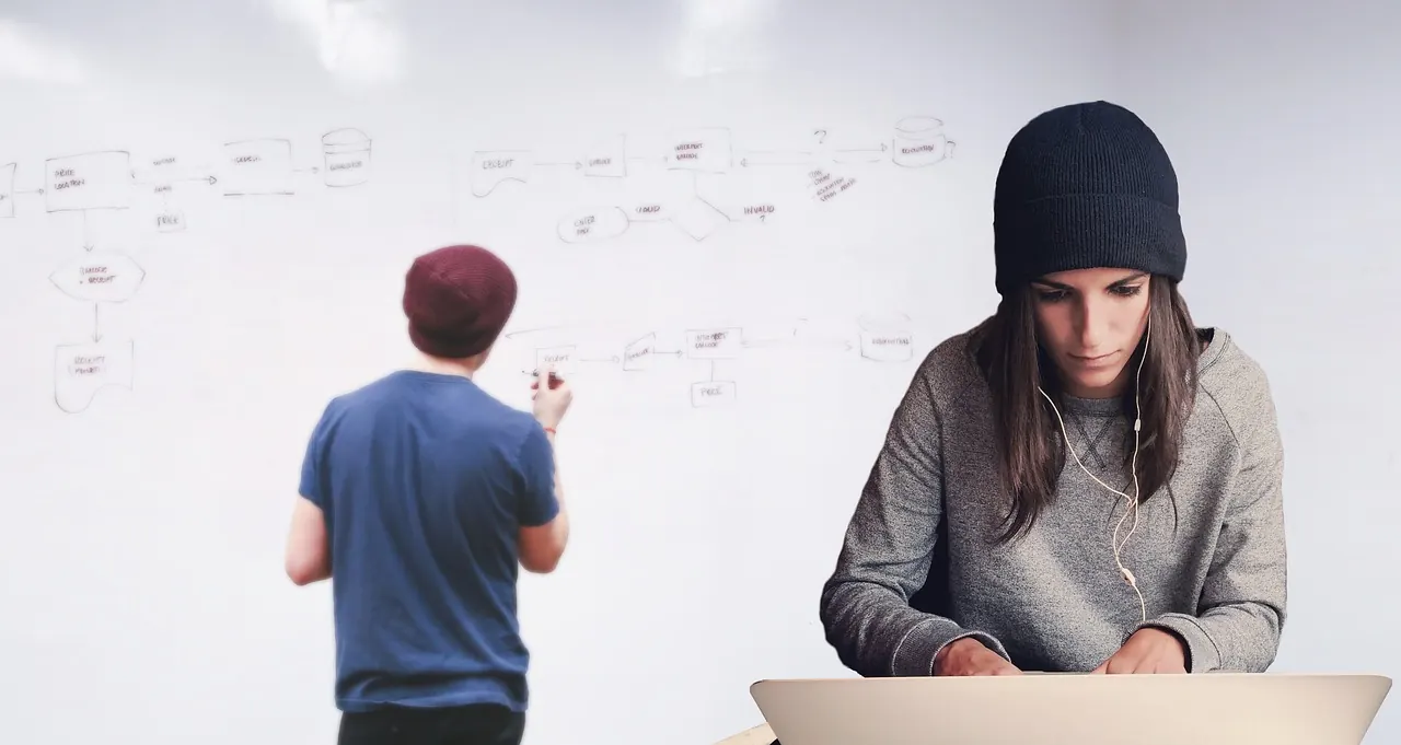 Team-Mitglied am Laptop vor Whiteboard mit Workflow-Diagramm — typischer Anwendungsfall für Planner Premium