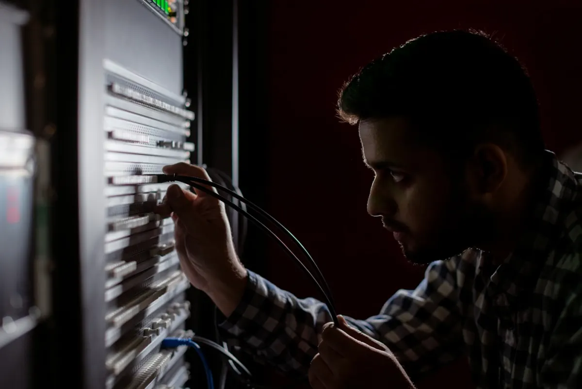 Netzwerk-Engineer konfiguriert Switch und Firewall in einem mittelständischen Serverraum — effizienter Netzwerk-Betrieb für KMU
