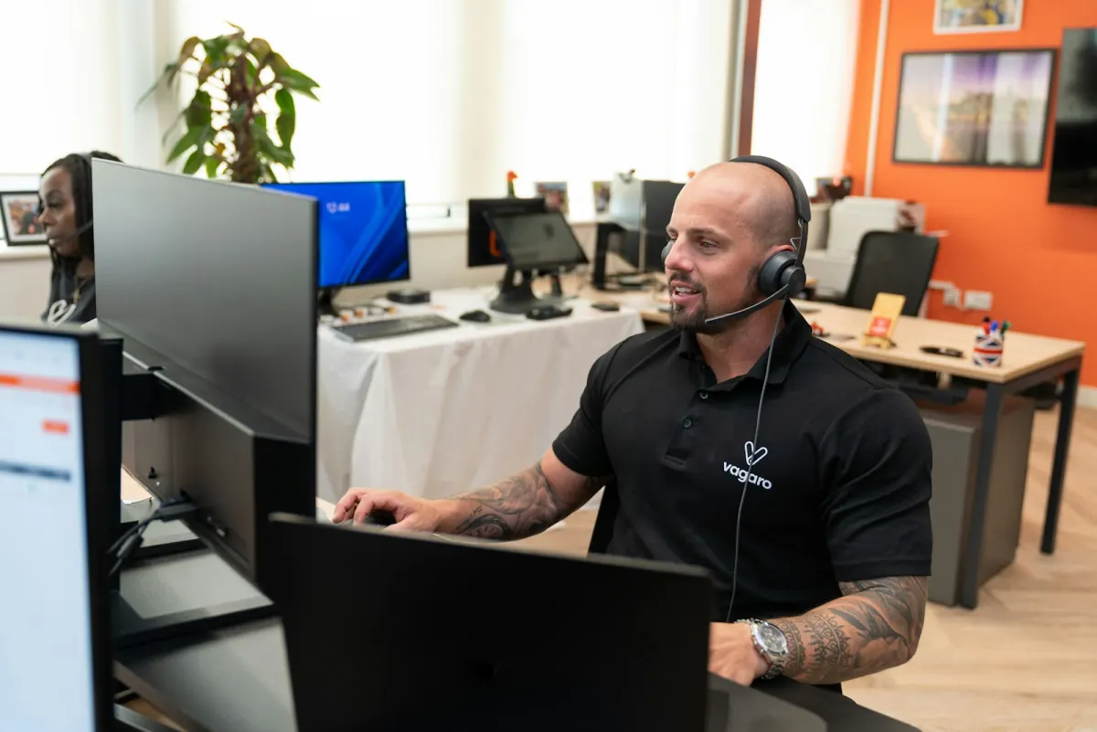 Helpdesk-Mitarbeiter am Headset bearbeitet PC-Hilfe-Ticket eines Hamburger Unternehmens