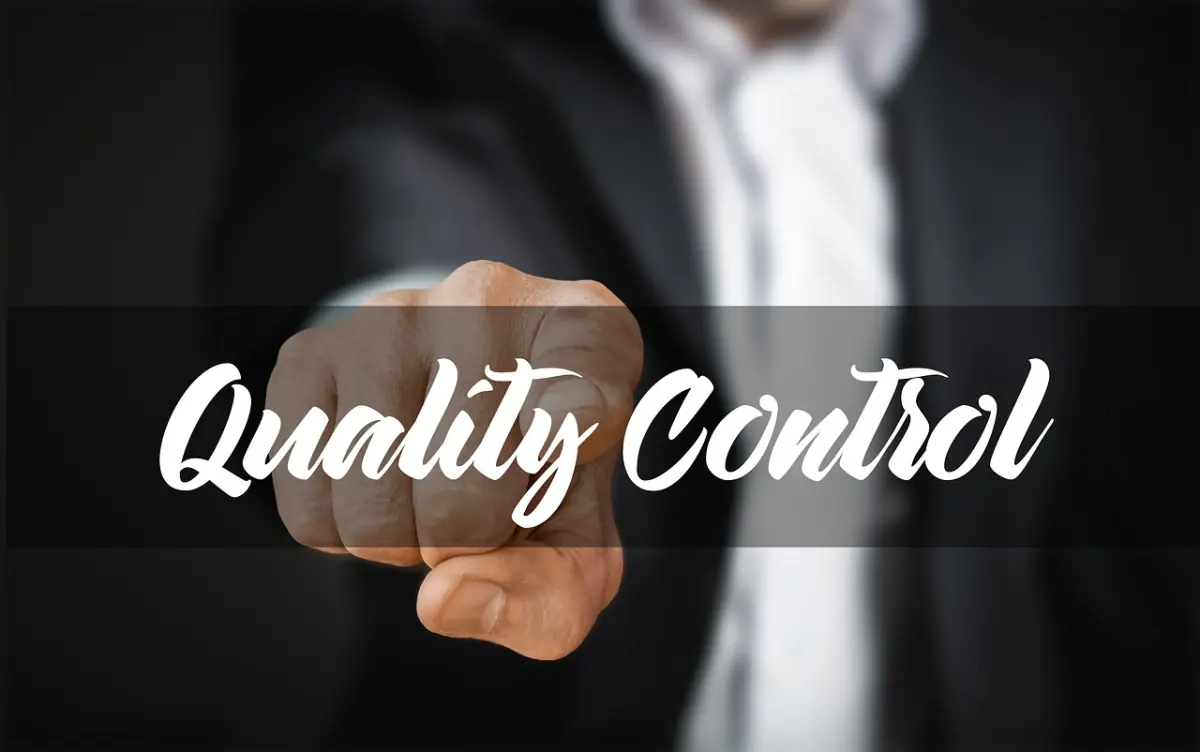 Geschäftsmann setzt einen Quality-Control-Stempel auf ein Dokument – sichtbare Qualitätssicherung in IT-Prozessen
